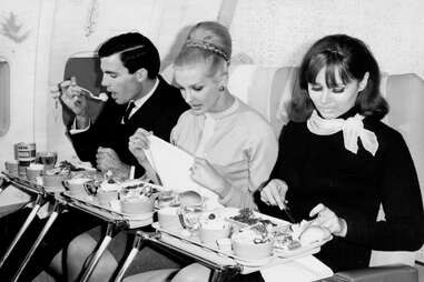Women eating meals on an airplane