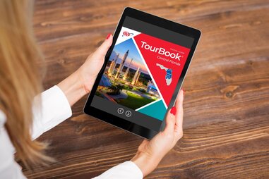 person reading aaa digital tour book on ipad