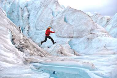 hiker leaping over glaciers 
