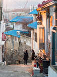 tourists taking pictures on a hilly seoul street