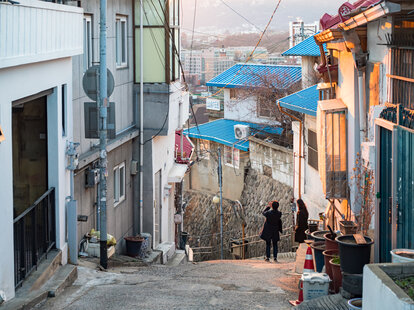 tourists taking pictures on a hilly seoul street