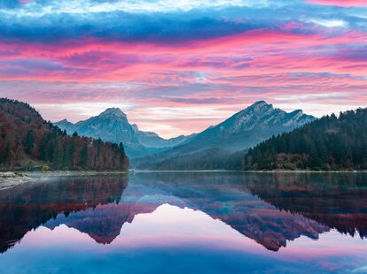 Peaceful autumn view on Obersee lake in Swiss Alps. Dramatic sunset sky and mountains reflections in clear water. Nafels village, Switzerland.