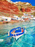 Breathtaking beautiful landscape of two fishing boats anchored to quay in fascinating blue water at the amazing old port panorama in Oia Ia village on Santorini Greek island in Aegean sea.