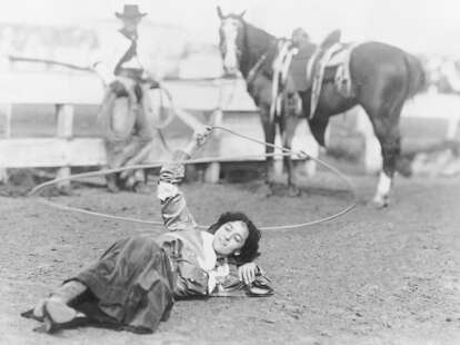 lady laying on the ground twirling a rope 