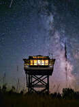 fire lookout tower at night during meteor shower