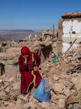 A woman sits amongst the rubble of her village that was almost completely destroyed by Friday's earthquake, on September 11, 2023 in Douzrou, Morocco. 