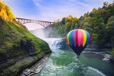 hot air balloon floating above river