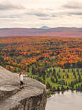 woman on cliff looking at autumn view