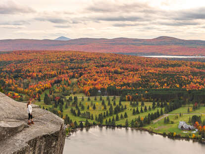 woman on cliff looking at autumn view