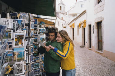 couple shopping for postcards