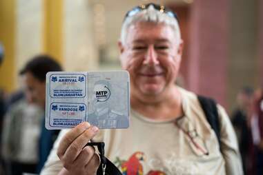 man shows passport stamps