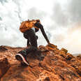 woman climbs mountaintop