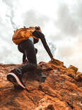 woman climbs mountaintop