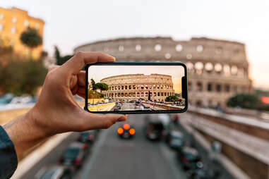 camera phone frames the coliseum in rome