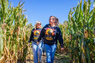 two women walking through corn maze 