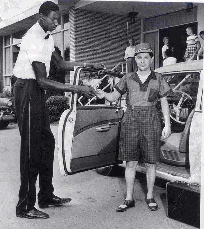 Basketball player Wilt Chamberlain towering over a hotel guest