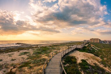 walkway south of furadouro beach in ovar on a stormy day at sunset
