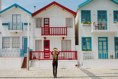 woman taking a photo of row of colorful houses