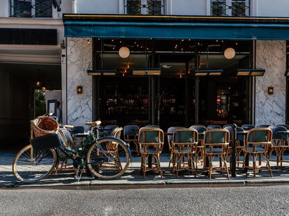 Cozy street with tables of cafe in Paris, France. Cityscape of Paris.