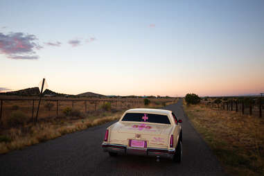 lowrider drives off into new mexico sunset