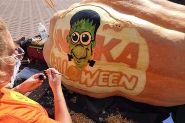 person carving pumpkin