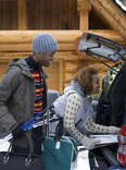 Couple packing trunk in the snow during winter holidays. 