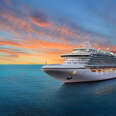 Luxury cruise ship sailing to port on sunrise. 