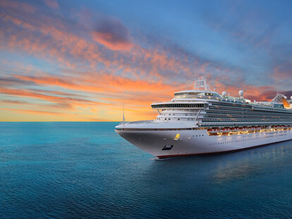 Luxury cruise ship sailing to port on sunrise.