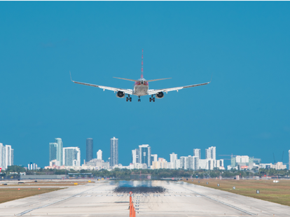 Airplane about to land at Miami International Airport with Downtown Miami skyline.
