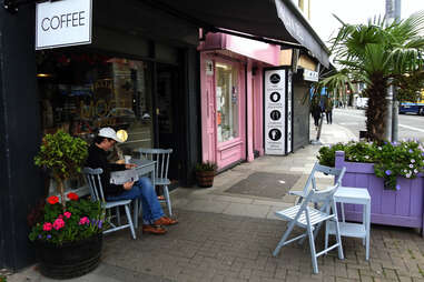 man reading in front of dublin coffee shop