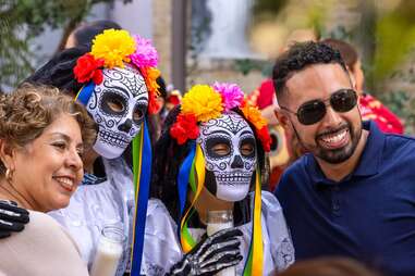 tourists taking photos with the performers at dia de los muertos in san antonio