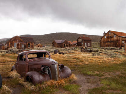 Rusting car and buildings in Bodie, California ghost town
