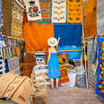 a woman looking at colorful rugs in Mexico 