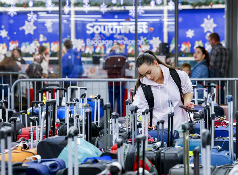 A woman searches for a suitcase in a baggage holding area for Southwest Airlines at Denver International Airport on December 28, 2022 in Denver, Colorado.