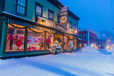 storefront of shaw's general store during snow covered twilight, stowe, vermont