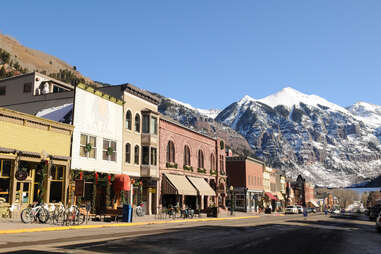 storefront of downtown telluride with snow-capped mountains in the background