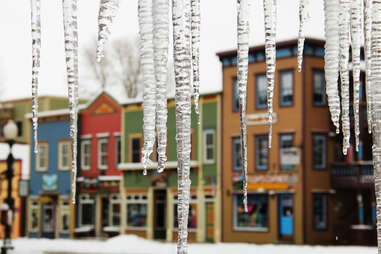 icicles hanging in front of colorful storefronts of crested butte, colorado