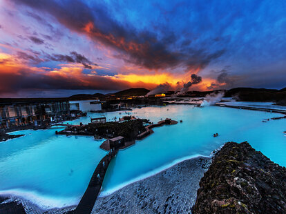 The Blue Lagoon in Iceland at sunset. Baby blue water fills volcanic pools amid a rocky and icy landscaped.