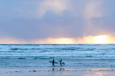 Two surfers hitting the waves after a winter storm in Vancouver Island, Canada.