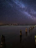 The Milky Way in the night sky over a broken pier in Kolka parish, Latvia