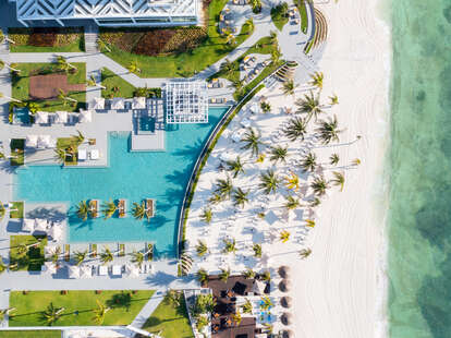 aerial view of all inclusive resort in costa mujeres mexico with trees and beach and a pool