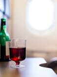 Plastic cup of red wine in the airplane. 