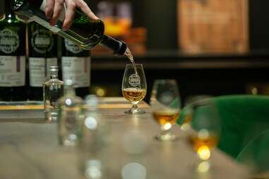 bartender pouring scotch into a glass