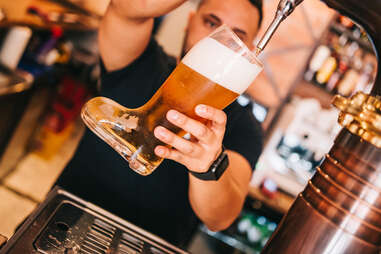 man filling glass boot with beer