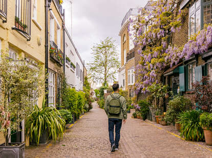man walking among mews houses in south kensington district, London, UK