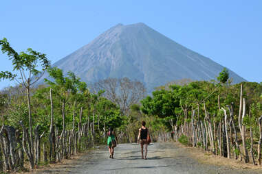 two people walking towards ometepe island volcano nicaragua