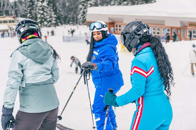 female ski instructor, helping, two women