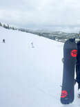 woman, standing, on a mountain, holding a snowboard