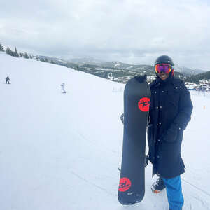 woman, standing, on a mountain, holding a snowboard