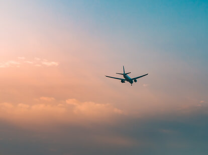Aircraft flying over clouds, aviation sunset background, essential transport for business and travel.